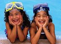 Fotografía de dos niñas sonriendo al lado de la piscina