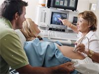 Fotografía de un médico al realizar un ultrasonido en una mujer embarazada