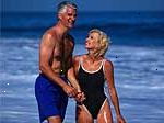 Imagen de una pareja de mediana edad en traje de baño jugando en la playa