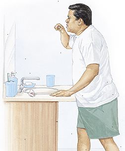 El hombre de pie en el lavabo de cepillarse los dientes con la espalda recta, flexionando ligeramente las caderas.
