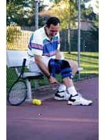 Fotografía de un hombre que llevaba una llave de rodilla, jugando al tenis