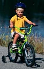 Fotografía de un niño, con un casco, una bicicleta